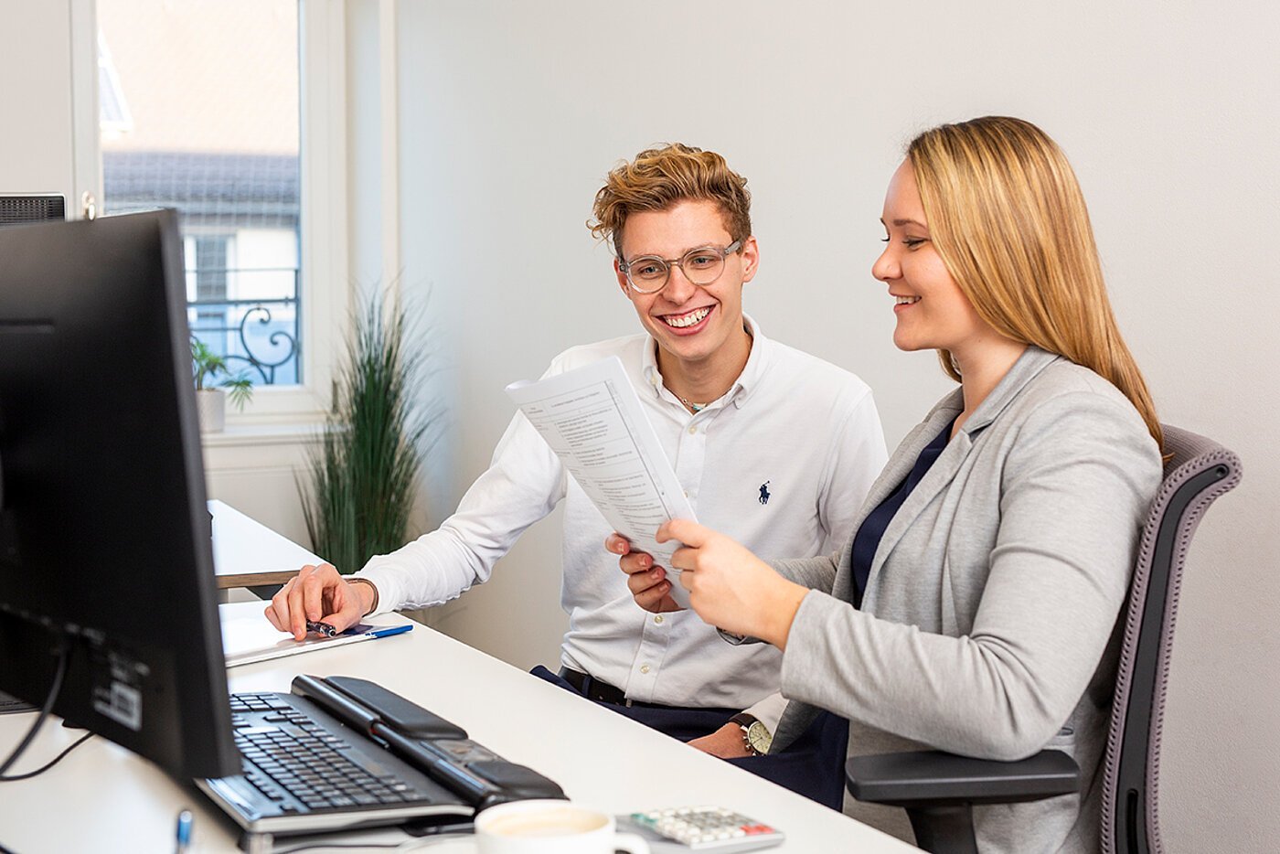 Ein Mann und eine Frau sitzen vor einem Computer.
